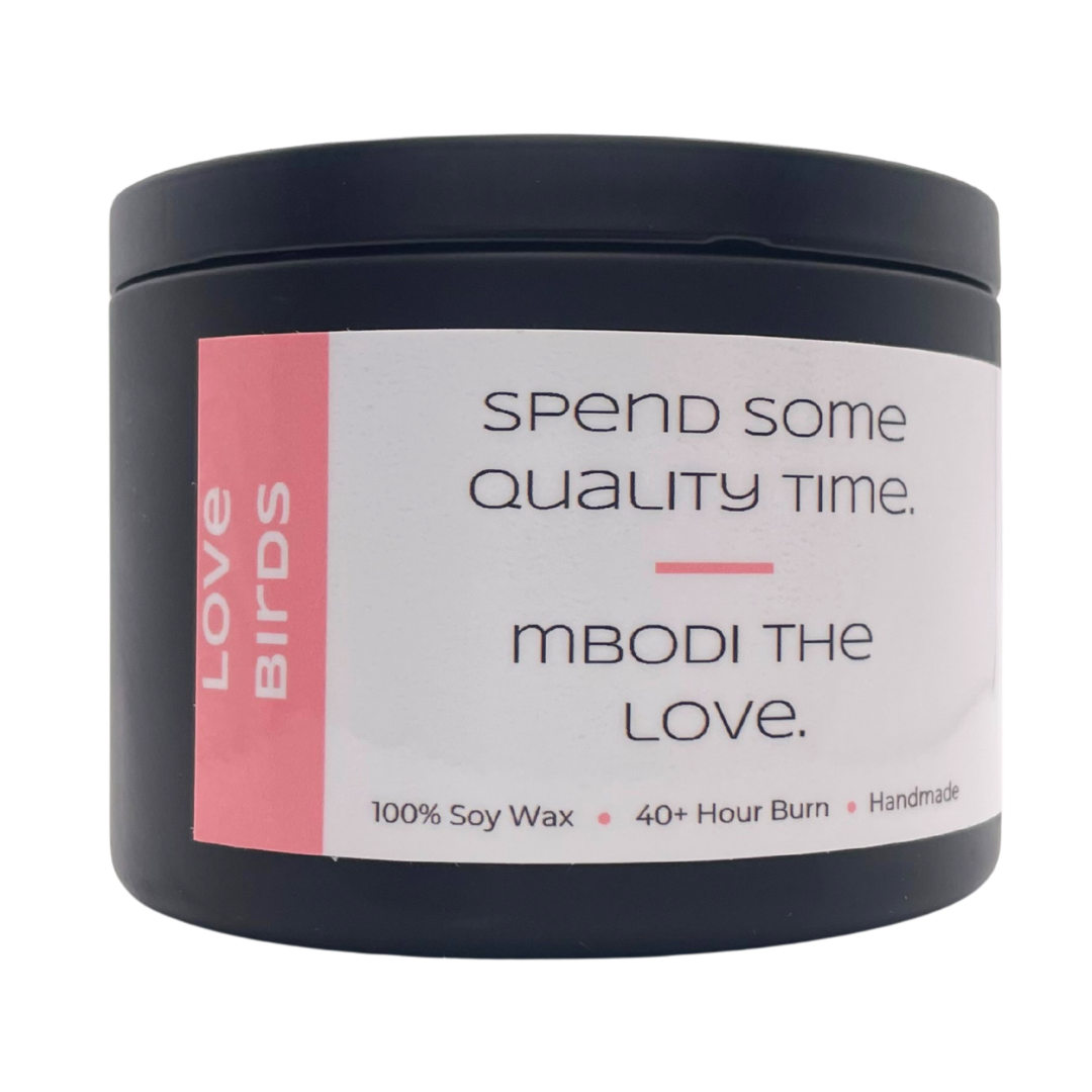 Mbodi 6 oz soy candle ‘Love Birds’ in metal tin with bright pink label designed for a warm, romantic atmosphere and connection