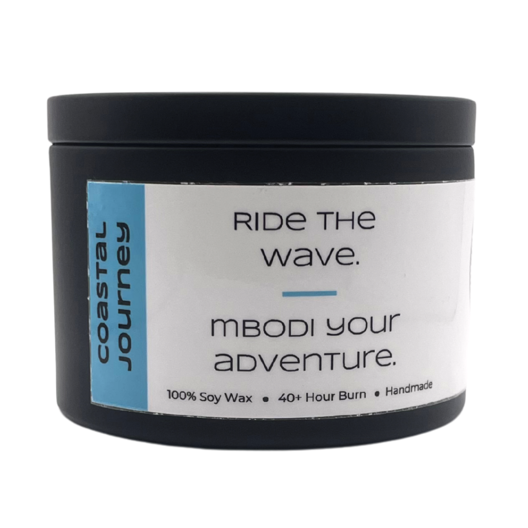 Mbodi 6 oz soy candle ‘Coastal Journey’ in metal tin with minimal beach blue label, crafted for a breezy, open, and restorative environment inspired by the coast