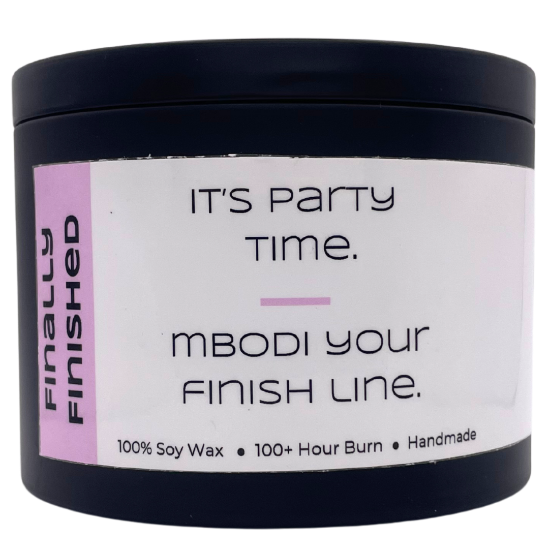 Mbodi 15 oz soy candle ‘Finally Finished’ in metal tin with soft toned pink label designed for celebrating, partying, and enjoying the weekend