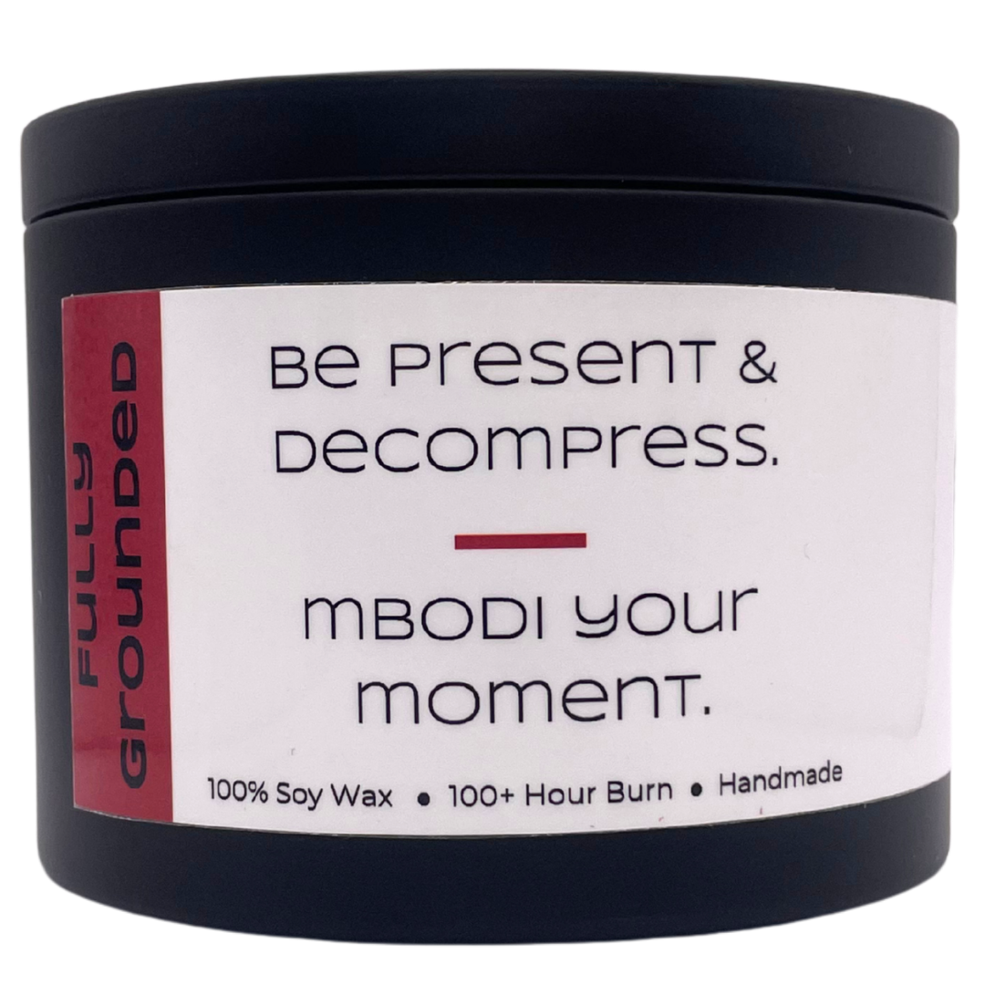 Mbodi 15 oz soy candle ‘Fully Grounded’ in metal tin with soft toned red label designed for stability, balance, and a calm grounded atmosphere