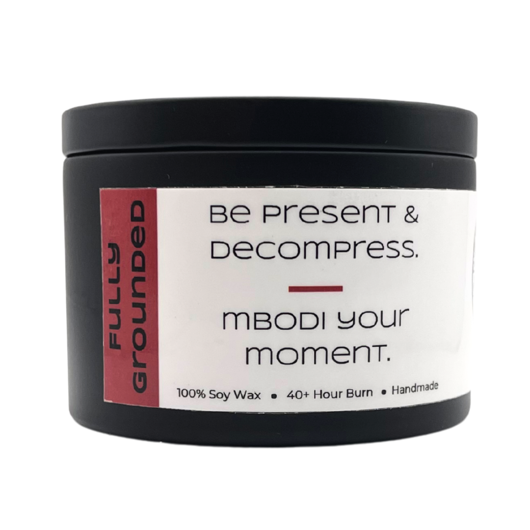 Mbodi 6 oz soy candle ‘Fully Grounded’ in metal tin with soft toned red label designed for stability, balance, and a calm grounded atmosphere