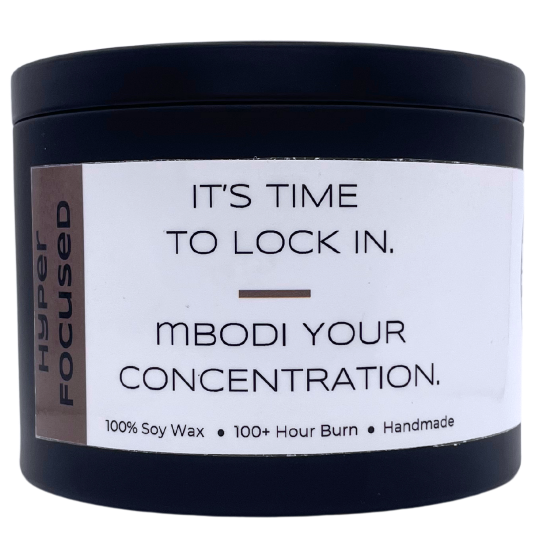 Mbodi 15 oz soy candle ‘Hyper Focused’ in metal tin with minimal label, crafted for high focus, disciplined energy, and mental precision