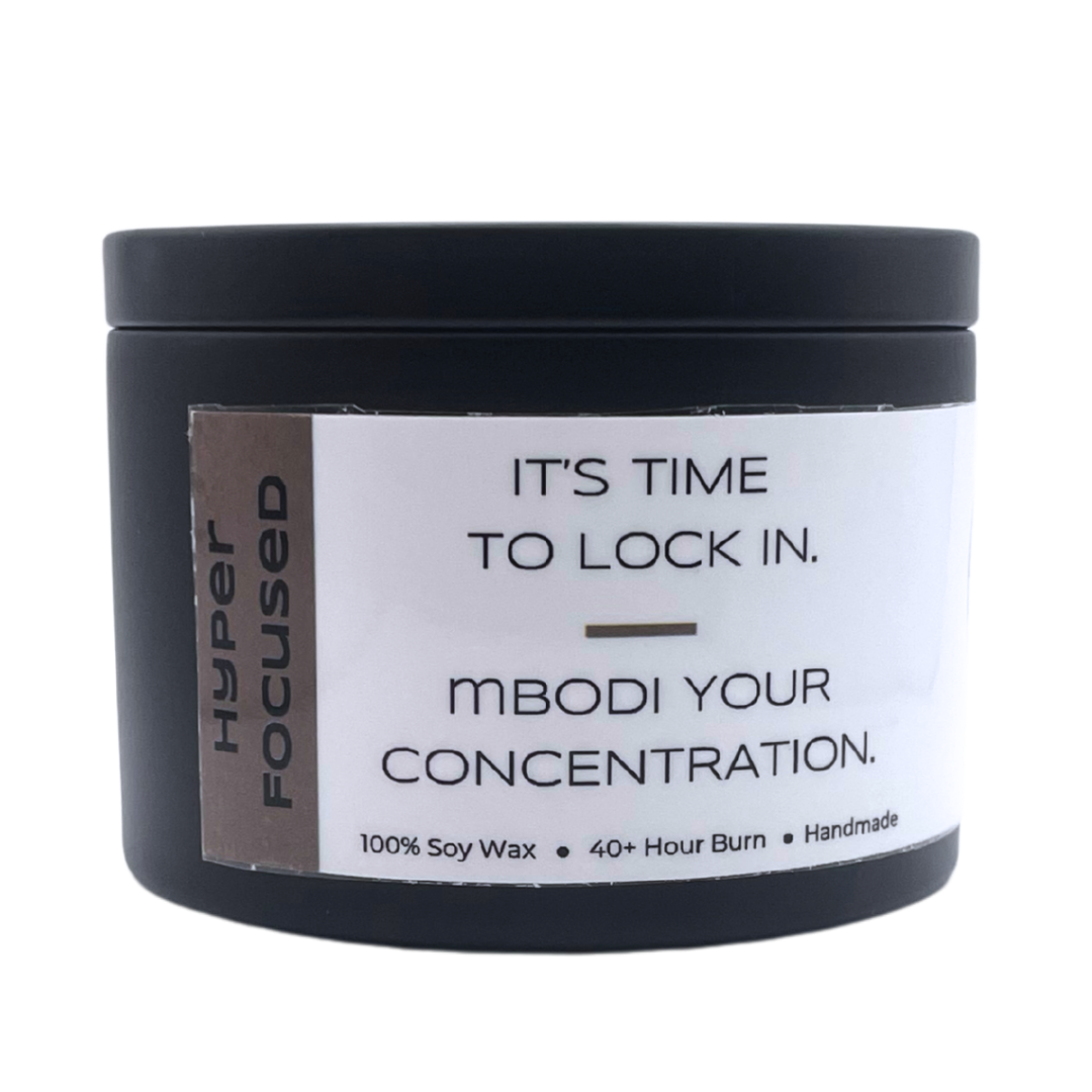 Mbodi 6 oz soy candle ‘Hyper Focused’ in metal tin with minimal label, crafted for high focus, disciplined energy, and mental precision