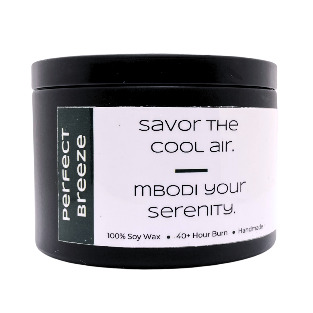 Mbodi 6 oz soy candle ‘Perfect Breeze’ in metal tin with dark green label designed for a fresh, airy atmosphere