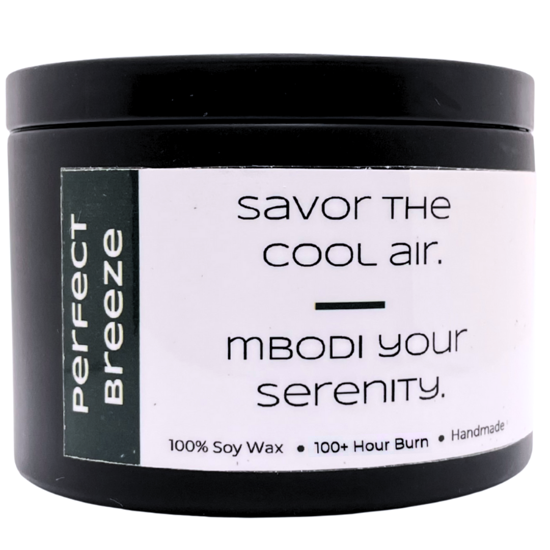 Mbodi 15 oz soy candle ‘Perfect Breeze’ in metal tin with dark green label designed for a fresh, airy atmosphere
