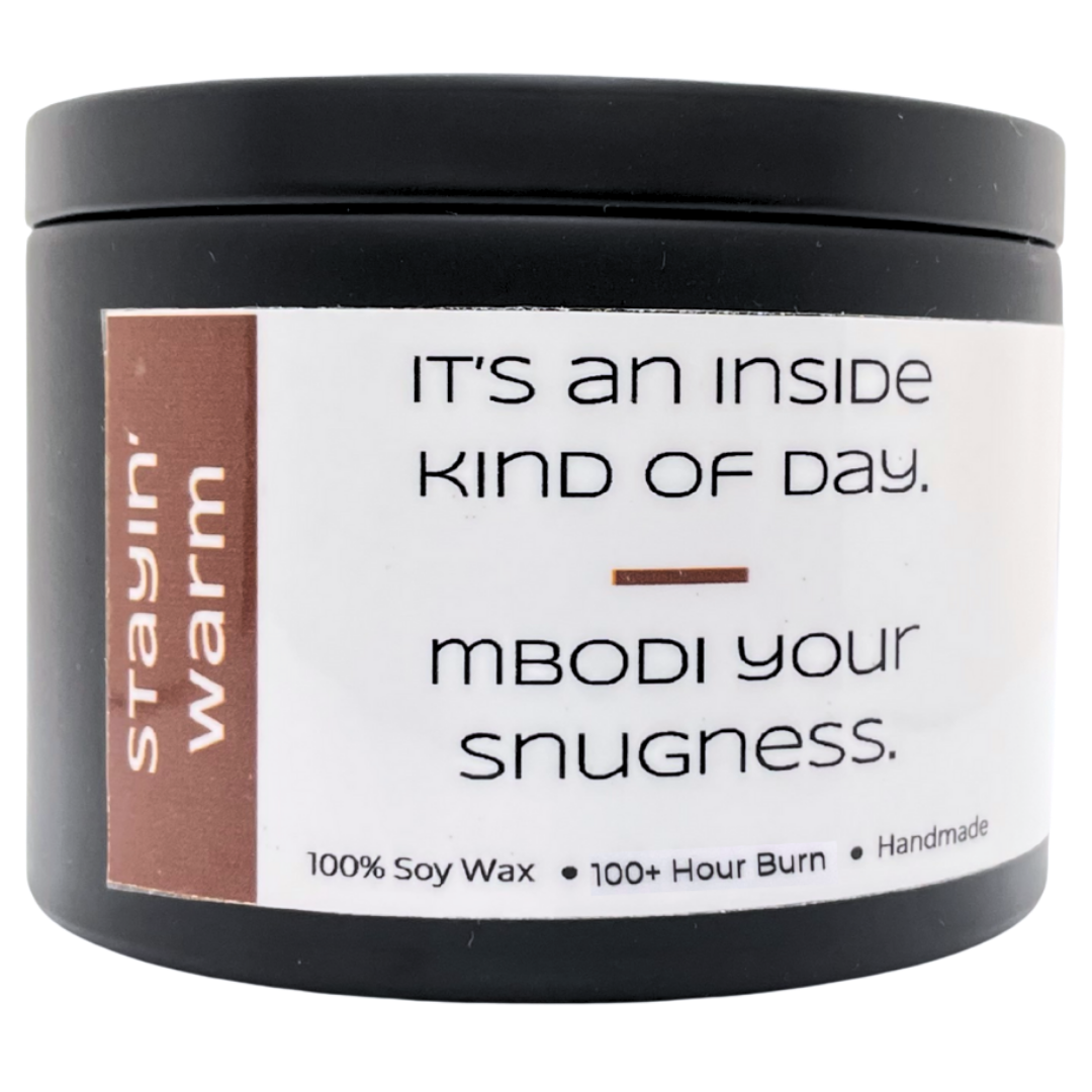 Mbodi 15 oz soy candle ‘Stayin Warm’ in metal tin with minimal label, crafted for a cozy, soothing, and comforting environment