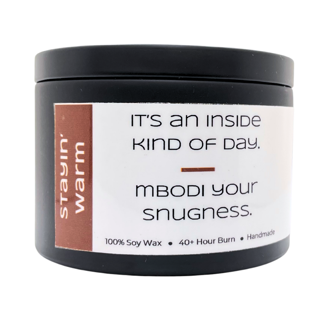 Mbodi 6 oz soy candle ‘Stayin Warm’ in metal tin with minimal label, crafted for a cozy, soothing, and comforting environment