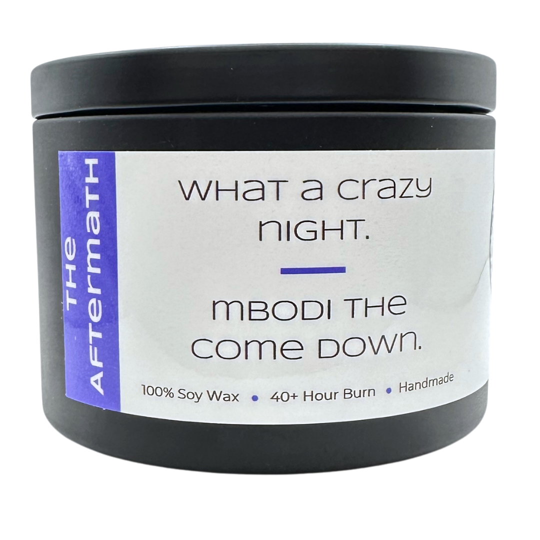 The Aftermath candle with dark purple label with text "What a crazy night. Mbodi the come down".